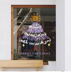 Detailed view of hand-drawn Christmas tree window decal on glass for festive shop decor
