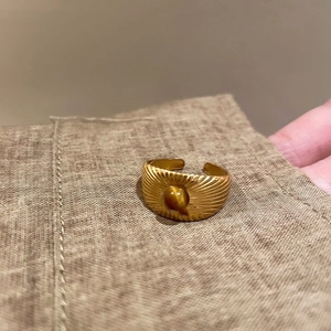 Detailed view of irregular adjustable gold ring featuring a round brown tiger eye stone