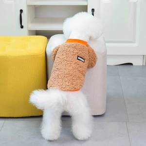 Detail of plush fleece pet vest in brown and orange on a small white dog