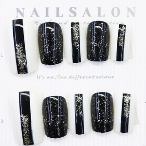 Medium length black and white glitter press-on nails with golden shimmer and stripes