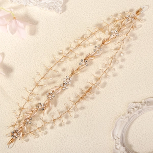 Detailed macro view of handmade bridal headband with gold leaves, pearls and rhinestones