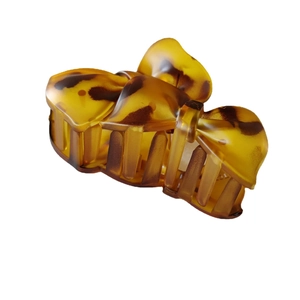 Matte tortoiseshell bow hair claw clip in amber leopard print for women's hair styling