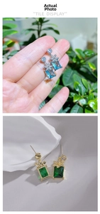 Detailed macro view of vintage square crystal earrings with floral accents in blue and green