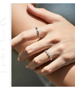 Close-up of S925 sterling silver chain and star rivet rings worn on female fingers