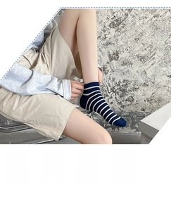 Detailed knit texture of blue striped cotton ankle socks with ribbed cuffs on feet