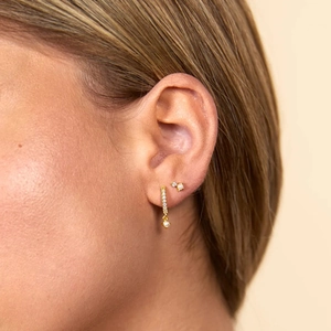 Detailed close-up of S925 silver gold-plated cartilage studs with crystals and pearls