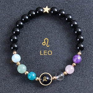 Detail of Leo zodiac bead bracelet with gold star pendant and colorful beads on dark background