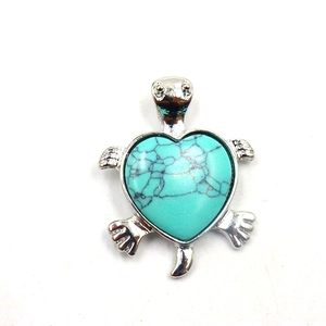 Detail van zilveren schildpad hanger met hartvormige turquoise steen en donkere adering