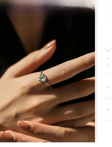 Macro shot of S925 silver heart ring with moonstone on hand under natural side light