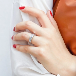 Detail of a pear-cut zircon on wide pave-set sterling silver ring band worn on finger