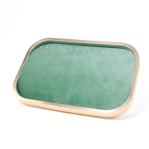 Detail view of emerald green velvet jewelry display tray with golden metal frame