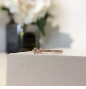 Detailed macro view of rose gold emerald cut cubic zirconia ring with side accent stones
