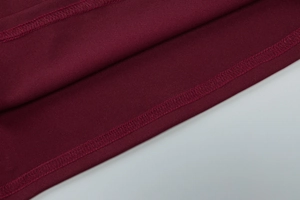 Detail of wine red dress showing high-quality plain weave fabric and professional stitching