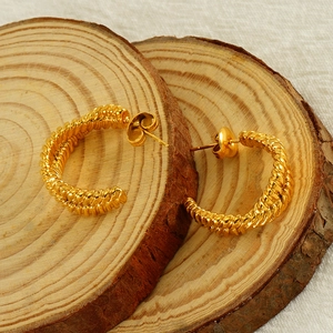 Chic 18K gold plated titanium steel irregular twisted hoop earrings on wooden display