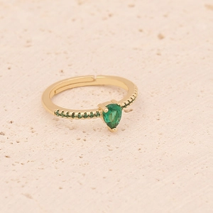 Macro shot of gold ring featuring pear-cut green zircon and shimmering side accents
