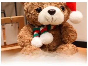 Close-up of soft plush brown teddy bear with festive knitted scarf and Christmas hat