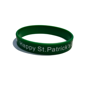 Macro detail of green silicone St. Patrick's Day wristband with white Happy St. Patrick's text