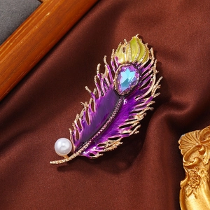 Detail of peacock feather brooch with purple enamel, colorful crystal and white pearl