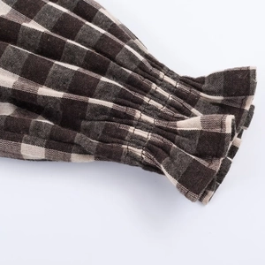 Detail of coffee and beige honeycomb checkered fabric with elastic ruffled cuffs