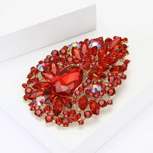 Exquisite gold alloy brooch featuring a large red pear-shaped rhinestone and crystals