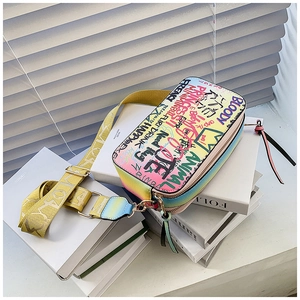 Macro detail of graffiti small square crossbody bag with dual zipper and wide shoulder strap