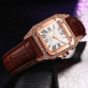 Close-up of square rose gold watch with sparkling rhinestones and Roman numerals dial