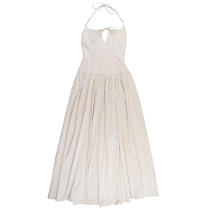 Détail d'une robe licou blanc cassé avec lien découpé au buste et jupe longue plissée