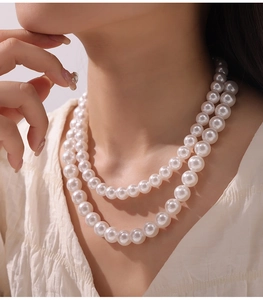 Dettaglio di una collana di perle a due fili con elegante finitura lucida su modella