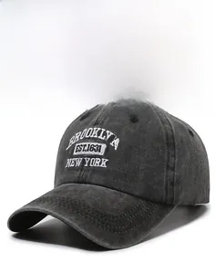Detailed close-up of embroidered Brooklyn lettering on washed charcoal baseball cap