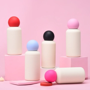 Creative 350ml matte water bottles with colorful spherical lids on geometric props