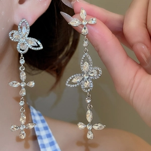 Detail of silver butterfly earrings with sparkling rhinestones and long tassel fringe