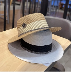 Dettaglio di cappelli in paglia intrecciata con texture e accessori a stella in metallo