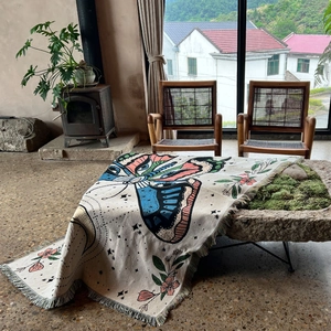 Detail of bohemian camping blanket with colorful butterfly pattern and fringed edges