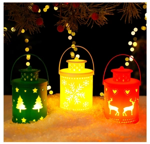 Three festive Christmas lanterns with tree and reindeer patterns on a snowy background