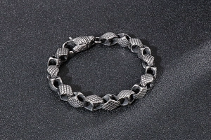 Close-up of vintage geometric waffle-pattern steel links on a men's punk bracelet