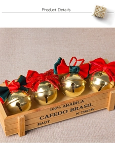 Close-up of golden Christmas bells with velvet ribbons and star cutouts on wood