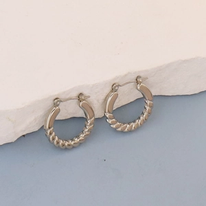 Detail showing silver hoop earrings with a mix of smooth and twisted rope textures