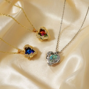 Three heart-shaped pendant necklaces in gold and silver with colorful zircon gemstones