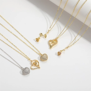 Elegant gold and silver rose heart necklaces with sparkling zircons on white background