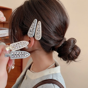 Close-up of four-piece set zircon hair clips featuring light blue and beige rhinestones