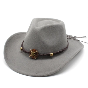 Detail of grey cowboy hat with brown braided band and golden sunflower relief embellishment