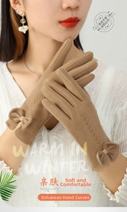 Close-up of warm thermal gloves featuring elegant bow detail and wheat embroidery