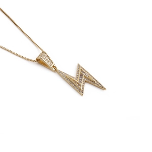Detailed close-up of a gold-plated lightning bolt pendant with sparkling zircons on a box chain