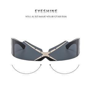 Close-up of frameless Y2K sunglasses with silver X-shaped metal bridge and grey lens