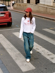 Λεπτομέρεια λευκού βαμβακερού μακρυμάνικου t-shirt με κόκκινη στάμπα στο δρόμο