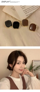 Detail of vintage square enamel earrings in black and brown with golden frames