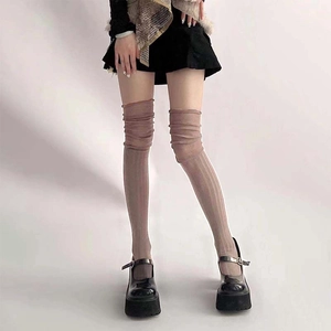 Detail of dusty pink knit over-knee socks with vertical textures and chunky Mary Jane shoes