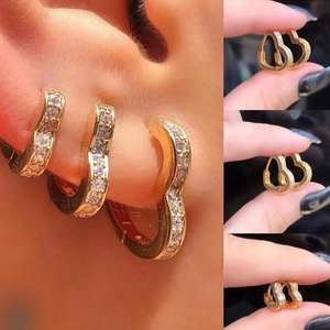 Elegant gold heart-shaped hoop earrings with sparkling cubic zirconia on female model