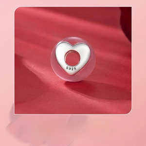 Detailed macro view of S925 sterling silver pink heart lampwork bead with hallmark