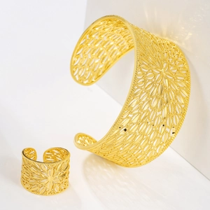 Close-up of gold-plated hollow floral cuff bracelet and adjustable matching ring set